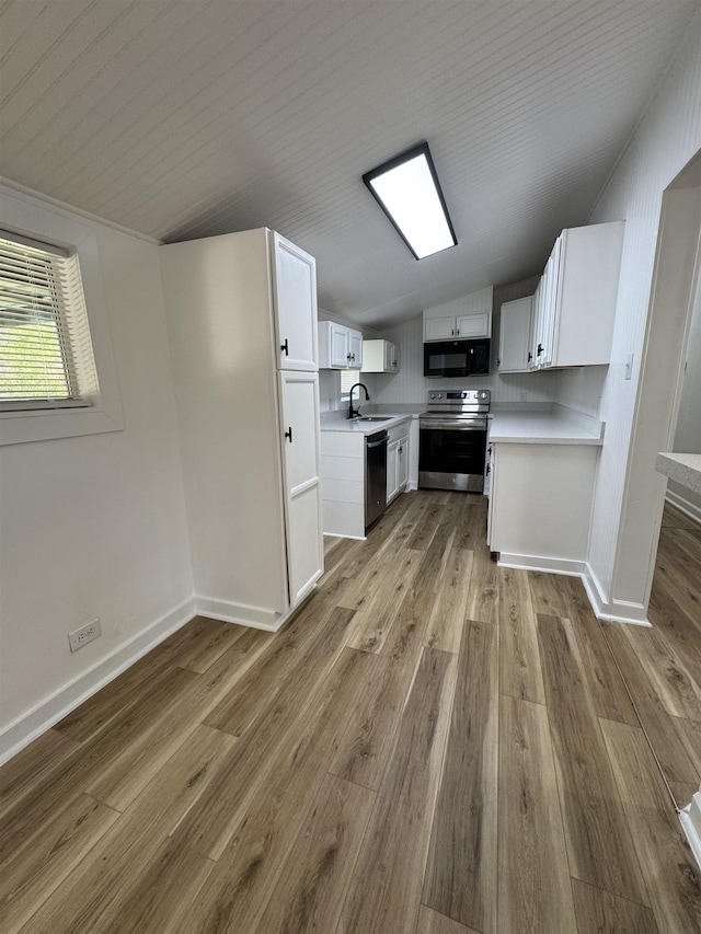 6250 Howe St, Groves, TX 77619 - kitchen with stainless steel appliances, light countertops, wood finished floors, lofted ceiling, and white cabinetry
