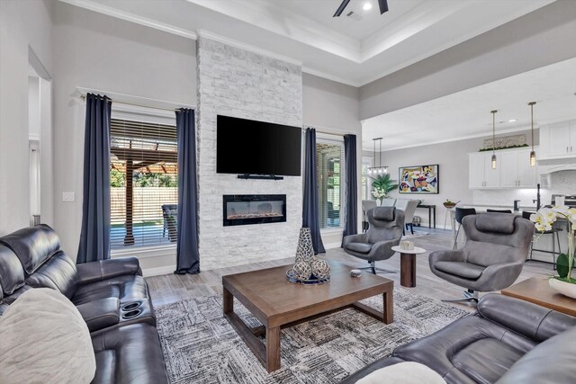 3435 Grey Hawk, Beaumont, TX 77707 - living room with light wood-type flooring, healthy amount of natural light, a stone fireplace, crown molding, and a ceiling fan