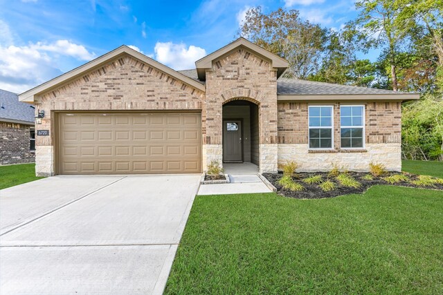 view of front of house featuring a garage and a front lawn