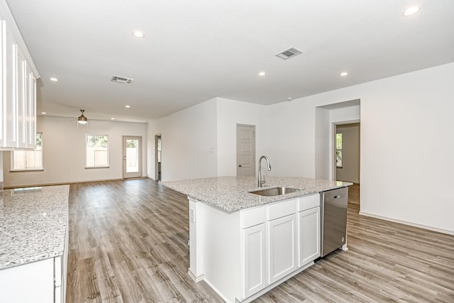 kitchen featuring a kitchen island with sink, white cabinets, sink, stainless steel dishwasher, and ceiling fan