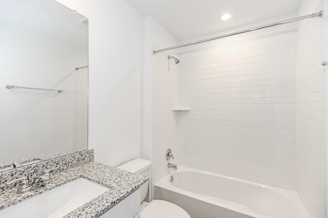 full bathroom featuring vanity, tiled shower / bath combo, and toilet