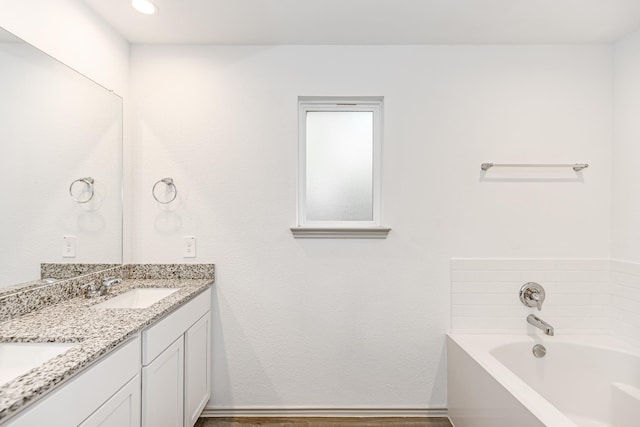 bathroom with a washtub and vanity