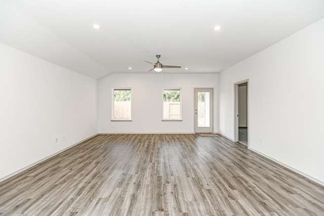 unfurnished living room with ceiling fan, lofted ceiling, and light wood-type flooring