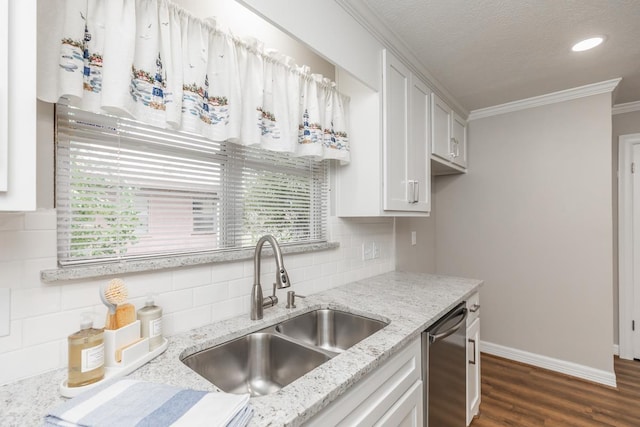 kitchen with backsplash, light stone counters, stainless steel dishwasher, sink, and white cabinetry