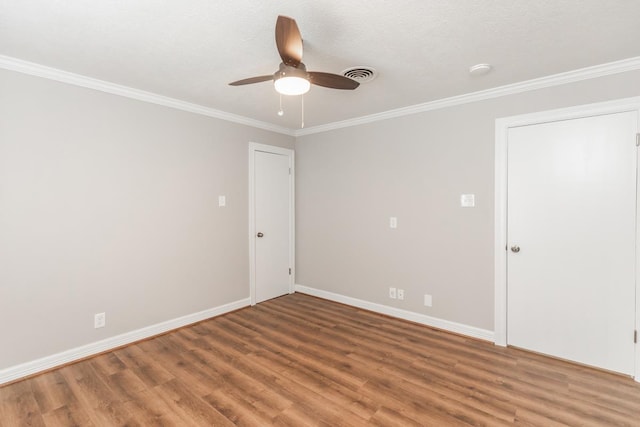 empty room with wood-type flooring, ceiling fan, and crown molding