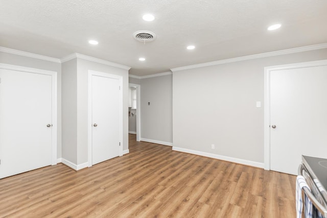 interior space featuring a textured ceiling, light wood-type flooring, and ornamental molding