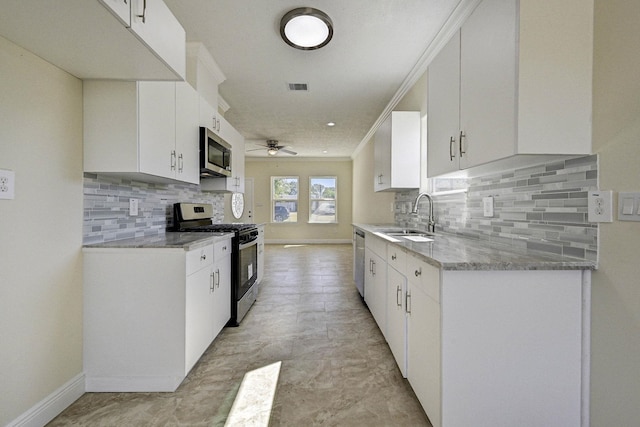 kitchen featuring ceiling fan, sink, white cabinets, and stainless steel appliances