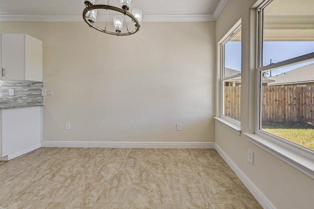 unfurnished dining area featuring crown molding and an inviting chandelier