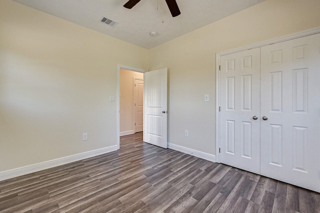 unfurnished bedroom with ceiling fan, a closet, and dark hardwood / wood-style floors