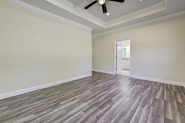 unfurnished room featuring a raised ceiling, ceiling fan, hardwood / wood-style floors, and ornamental molding