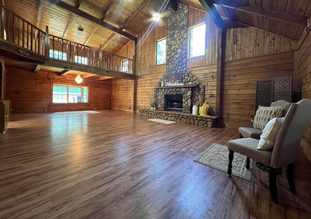 1205 Douglas St, Vidor, TX 77662 - living area featuring wooden walls, wood finished floors, high vaulted ceiling, a fireplace, and a wooden ceiling with exposed beams