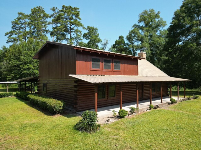 1205 Douglas St, Vidor, TX 77662 - view of property exterior with a yard, a chimney, a patio area, and log exterior