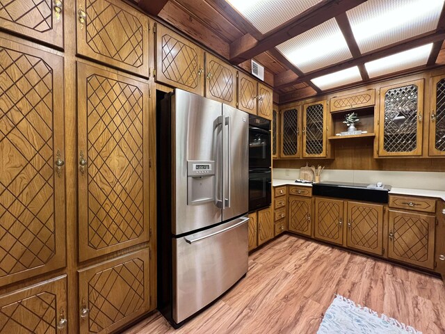 1205 Douglas St, Vidor, TX 77662 - kitchen featuring stainless steel fridge, light wood finished floors, light countertops, brown cabinets, and open shelves
