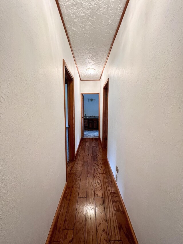 1205 Douglas St, Vidor, TX 77662 - hallway featuring a textured ceiling, dark wood-style flooring, and crown molding