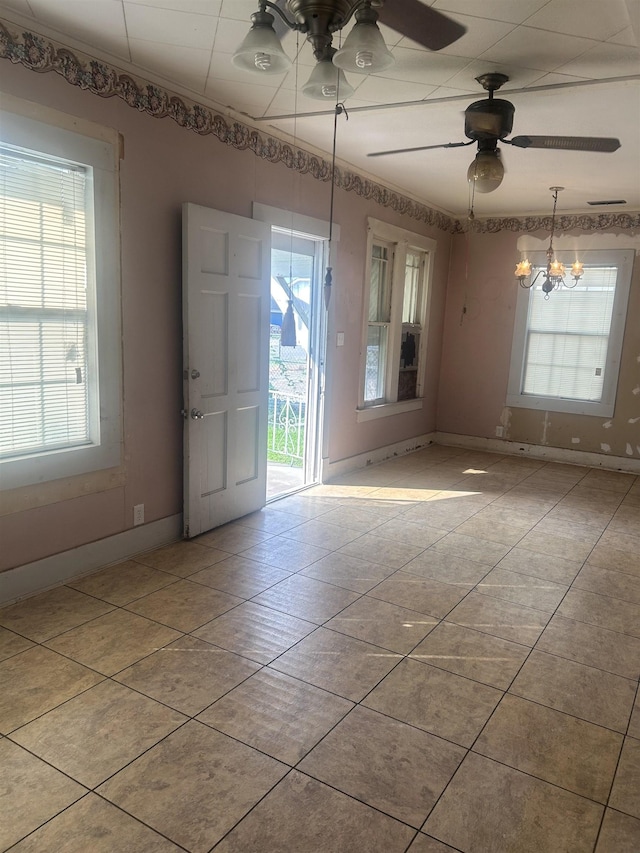 3924 7th St, Port Arthur, TX 77642 - tiled empty room with plenty of natural light, a chandelier, and ceiling fan