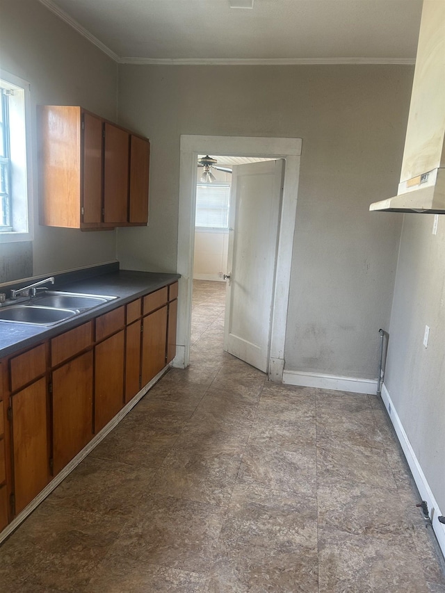3924 7th St, Port Arthur, TX 77642 - kitchen with exhaust hood, plenty of natural light, crown molding, dark countertops, and brown cabinets