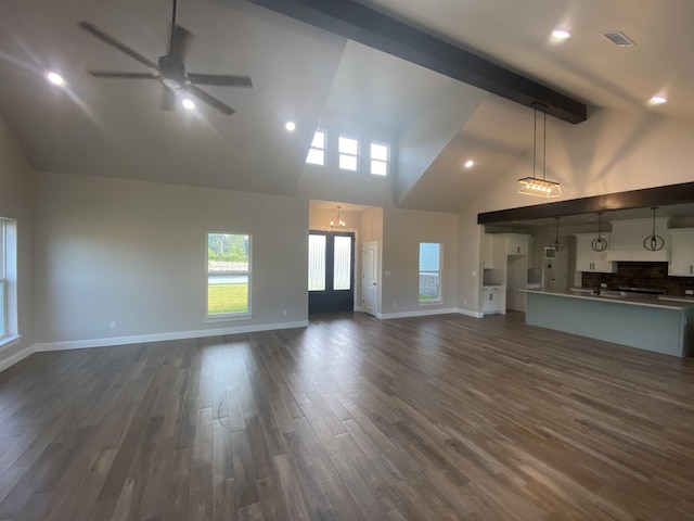 unfurnished living room featuring beamed ceiling, dark hardwood / wood-style floors, ceiling fan, and high vaulted ceiling