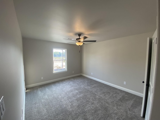 empty room featuring dark colored carpet and ceiling fan