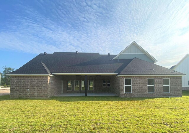 rear view of house with a lawn and a patio area