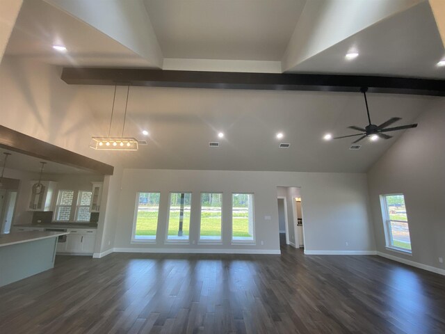 unfurnished living room featuring ceiling fan, beam ceiling, dark wood-type flooring, and high vaulted ceiling