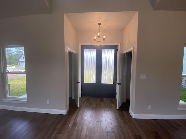 entrance foyer featuring french doors, dark hardwood / wood-style floors, and a notable chandelier