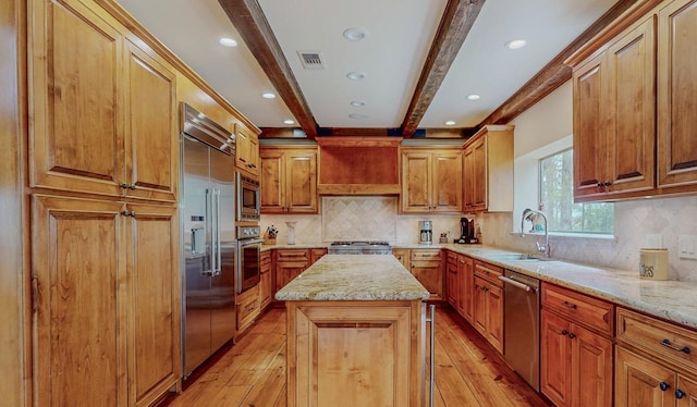10309 Bussey Rd, Silsbee, TX 77656 - kitchen with built in appliances, light wood-type flooring, beamed ceiling, a sink, and a kitchen island