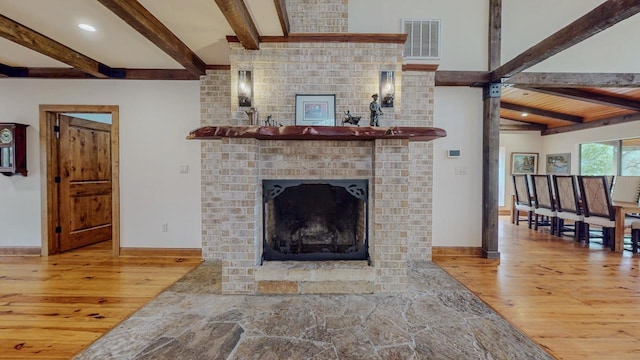 10309 Bussey Rd, Silsbee, TX 77656 - living room with wood-type flooring, beam ceiling, a fireplace, and baseboards