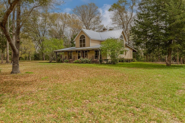 10309 Bussey Rd, Silsbee, TX 77656 - view of side of home featuring covered porch, a lawn, and metal roof