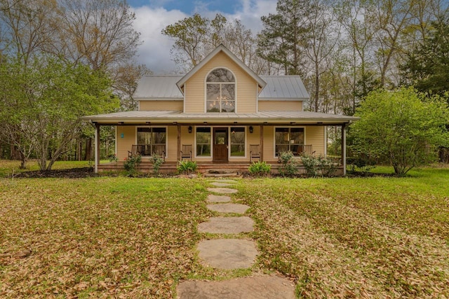 10309 Bussey Rd, Silsbee, TX 77656 - farmhouse with covered porch, a front yard, and metal roof