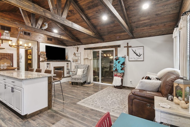 living room with lofted ceiling with beams, dark hardwood / wood-style floors, an inviting chandelier, and wood ceiling