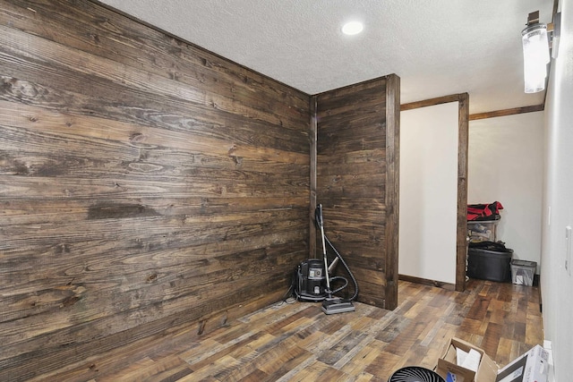 interior details featuring wood walls, hardwood / wood-style floors, and a textured ceiling