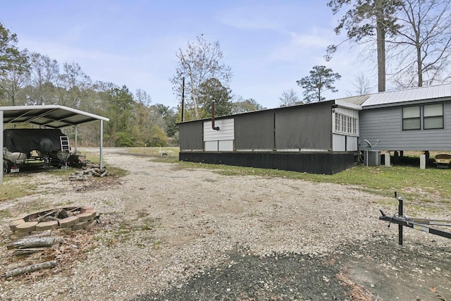 view of side of property featuring central AC and a carport