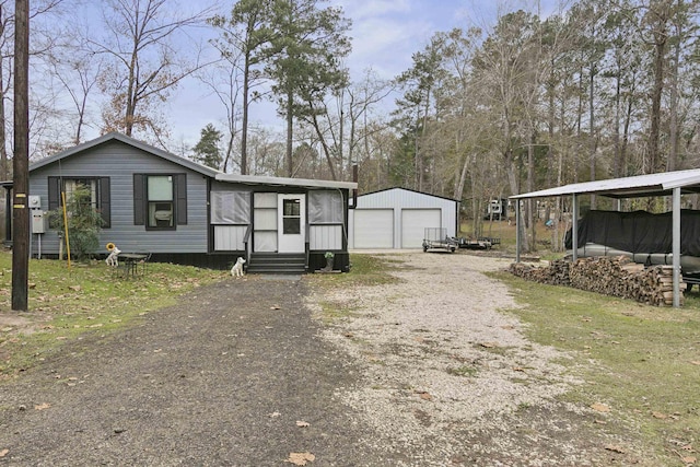 manufactured / mobile home with a carport, an outdoor structure, and a garage