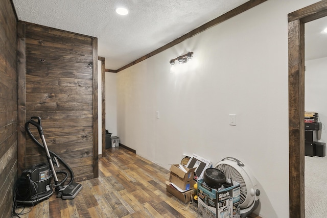 interior space featuring hardwood / wood-style flooring, crown molding, and a textured ceiling