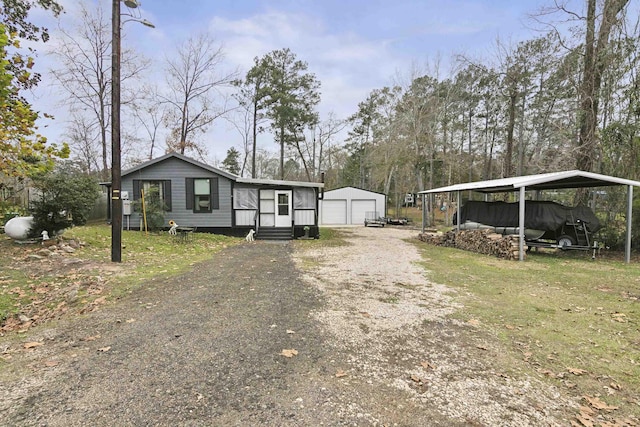 view of front of property with a front yard, a garage, a carport, and an outdoor structure