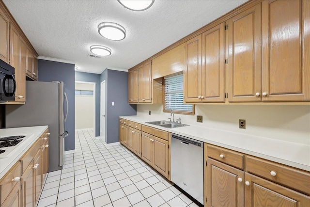 6250 Carnation Dr, Beaumont, TX 77706 - kitchen with appliances with stainless steel finishes, a sink, light countertops, a textured ceiling, and light tile patterned floors