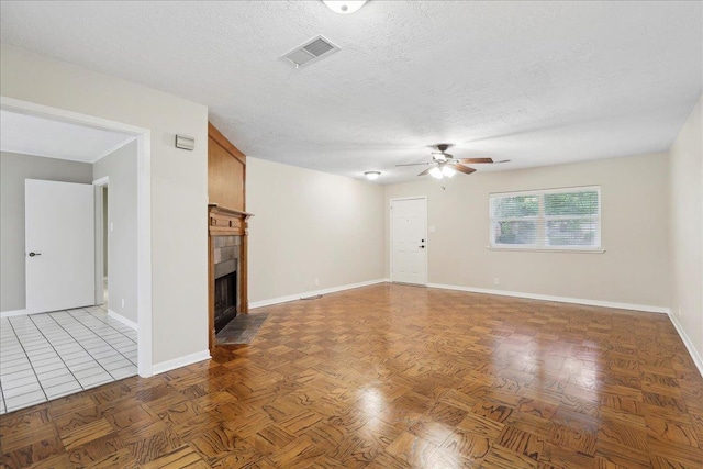6250 Carnation Dr, Beaumont, TX 77706 - unfurnished living room with ceiling fan, a tiled fireplace, baseboards, and a textured ceiling