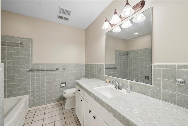 6250 Carnation Dr, Beaumont, TX 77706 - bathroom featuring tile walls, tile patterned flooring, vanity, toilet, and a wainscoted wall
