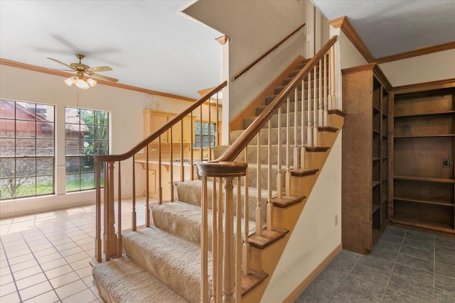 stairway with tile patterned floors, ceiling fan, and crown molding