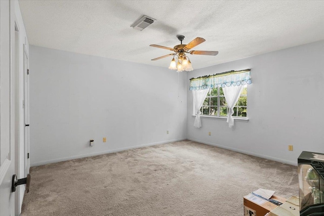 carpeted empty room featuring ceiling fan and a textured ceiling