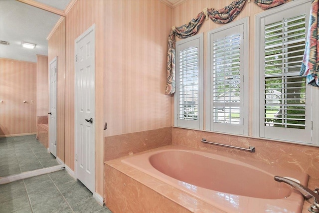 bathroom with tile patterned flooring and a tub to relax in