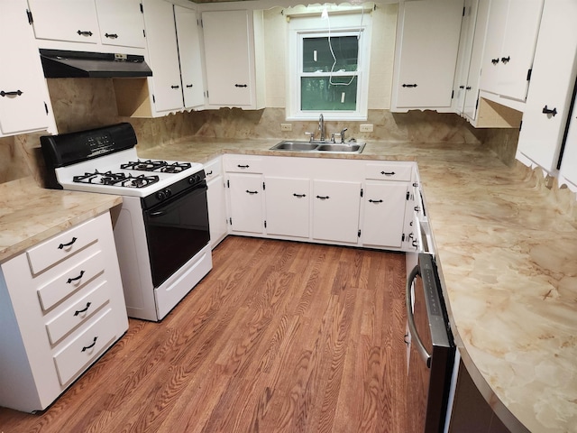 kitchen featuring sink, range with gas stovetop, white cabinets, and light wood-type flooring