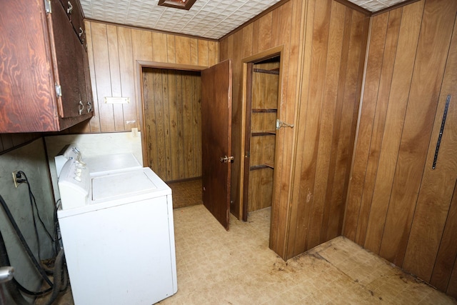 laundry area with cabinets, washing machine and dryer, and wooden walls