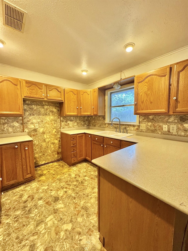 6219 16th St, Port Arthur, TX 77642 - kitchen with light countertops, a sink, brown cabinets, visible vents, and decorative backsplash
