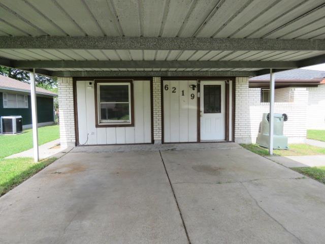 6219 16th St, Port Arthur, TX 77642 - property entrance with brick siding, central AC, and a carport
