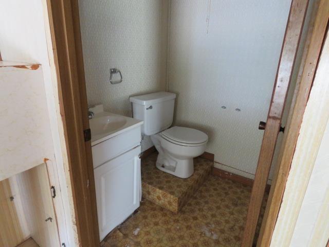 6219 16th St, Port Arthur, TX 77642 - half bathroom with toilet, vanity, and wallpapered walls