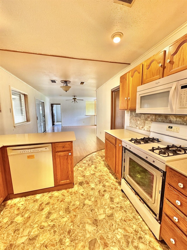 6219 16th St, Port Arthur, TX 77642 - kitchen with brown cabinetry, ceiling fan, light countertops, and white appliances