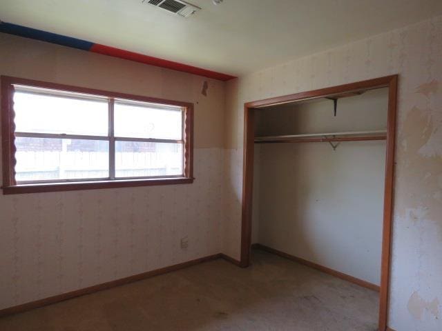 6219 16th St, Port Arthur, TX 77642 - unfurnished bedroom featuring a closet, wallpapered walls, baseboards, light colored carpet, and visible vents