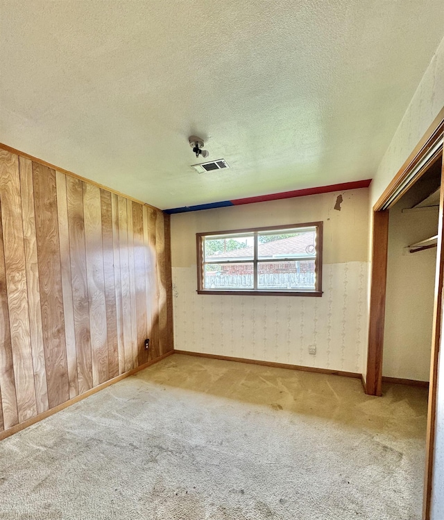 6219 16th St, Port Arthur, TX 77642 - unfurnished bedroom featuring wallpapered walls, carpet flooring, and a textured ceiling