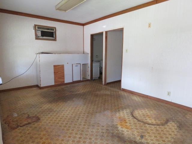 6219 16th St, Port Arthur, TX 77642 - spare room featuring baseboards, crown molding, and an AC wall unit